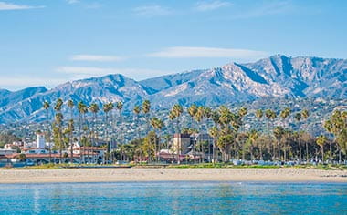 The Mediterranean style coastline of Santa Barbara, lined with palm trees and flanked by mountains, USA